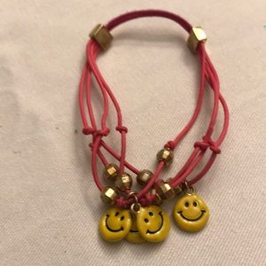 Pink bracelet with dangling smiley faces